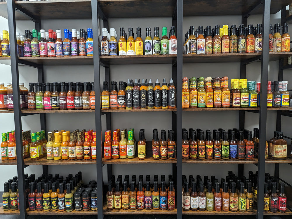Shelves of small-batch craft hot sauce bottles at SCOVILLED