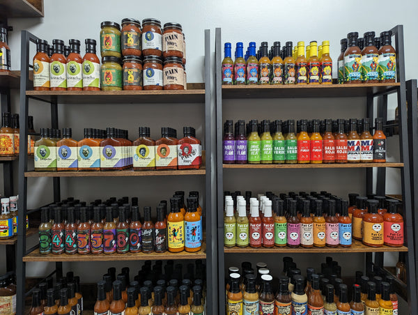 Rows of small-batch hot sauces from independent makers on SCOVILLED’s shelves